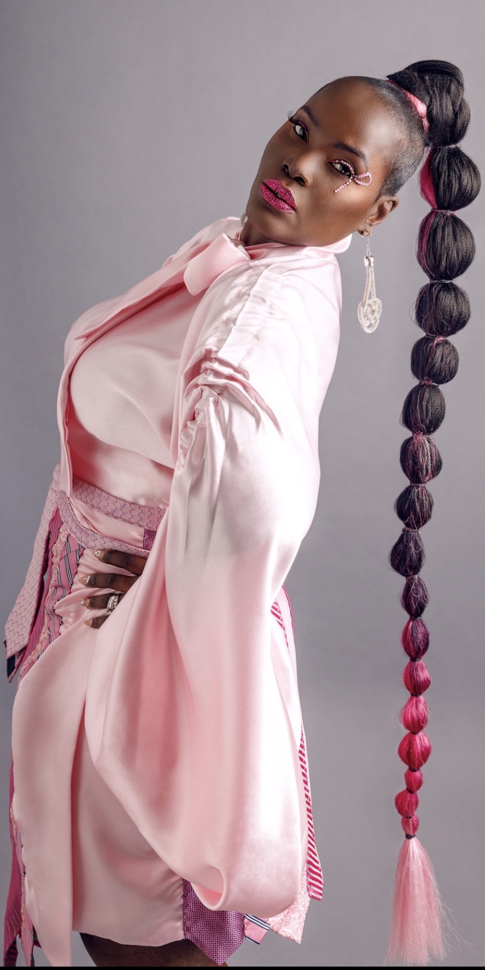 Full-length editorial portrait of Suzette Michelle, founder of Survivor Speaks, in a pink satin look photographed in studio, November 2023