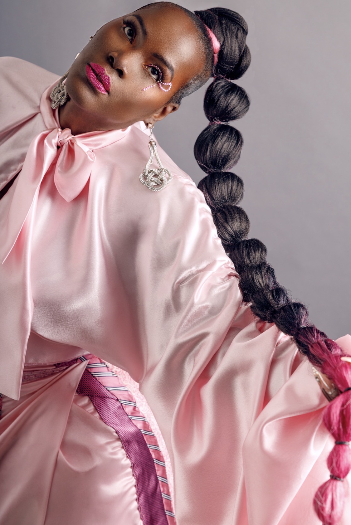 Suzette Michelle in a pink editorial look featuring the custom awareness tie design, photographed in studio, November 2023